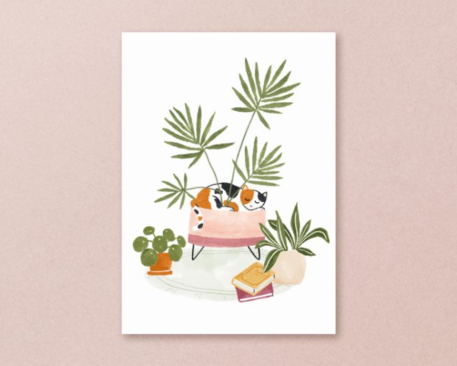 postkaart met handgemaakte illustratie van een lapjeskat die in de pot van een palm ligt, met andere planten en boeken erom heen. Roze en groene tinten.